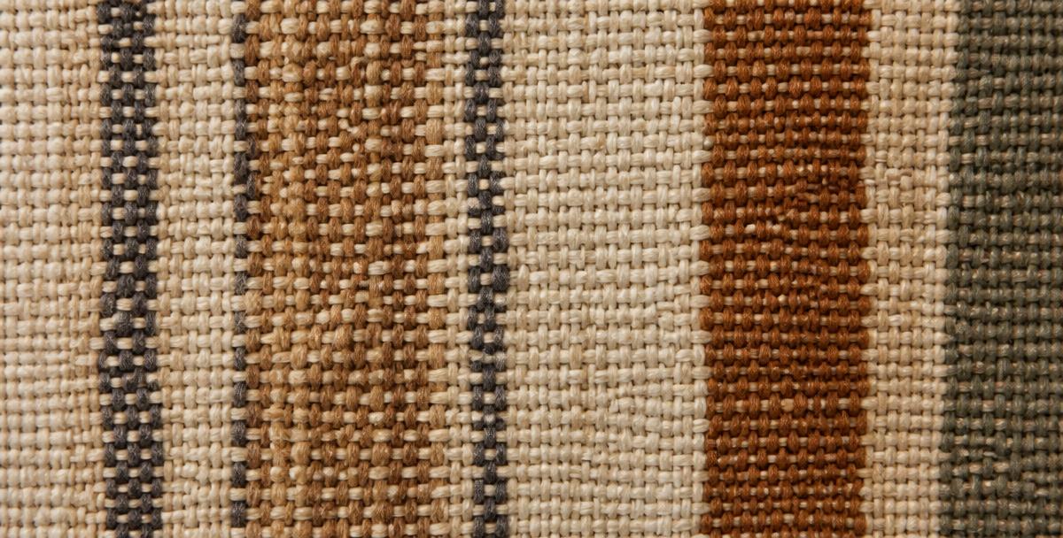 Close-up of a hand-woven textile in warm earthy tones